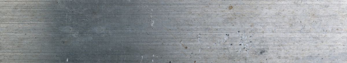 A brushed steel surface marked with fine machining lines.