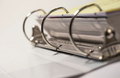 A ring binder standing open, its rings and paper in close focus.